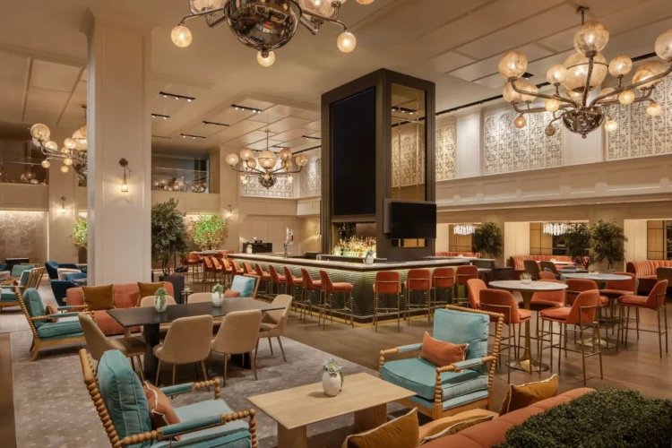 A spacious lobby with a bar, seating areas, and high ceilings.