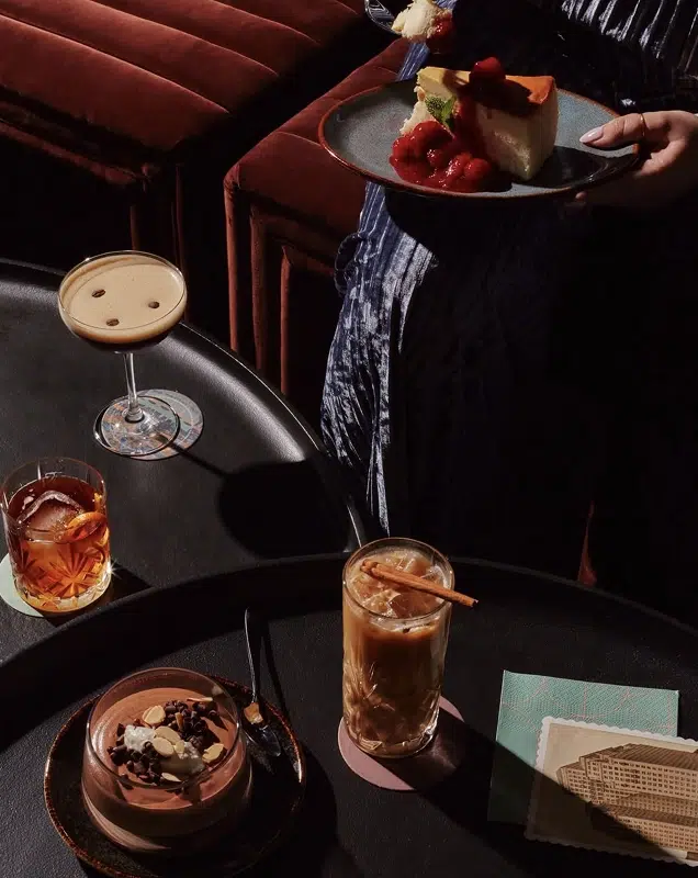 A selection of drinks and desserts on a table in a bar.