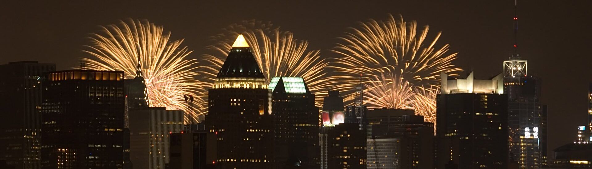 a city skyline with fireworks exploding in the night sky